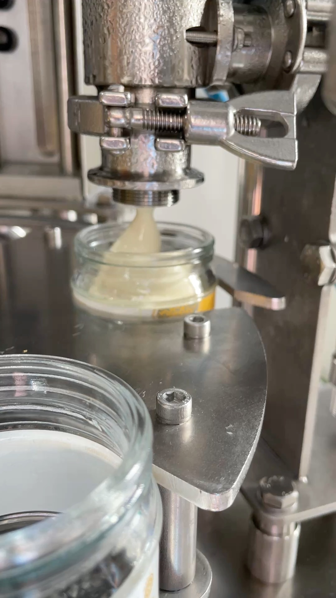 A glass jar being filled with fresh yoghurt at the Annie's dairy