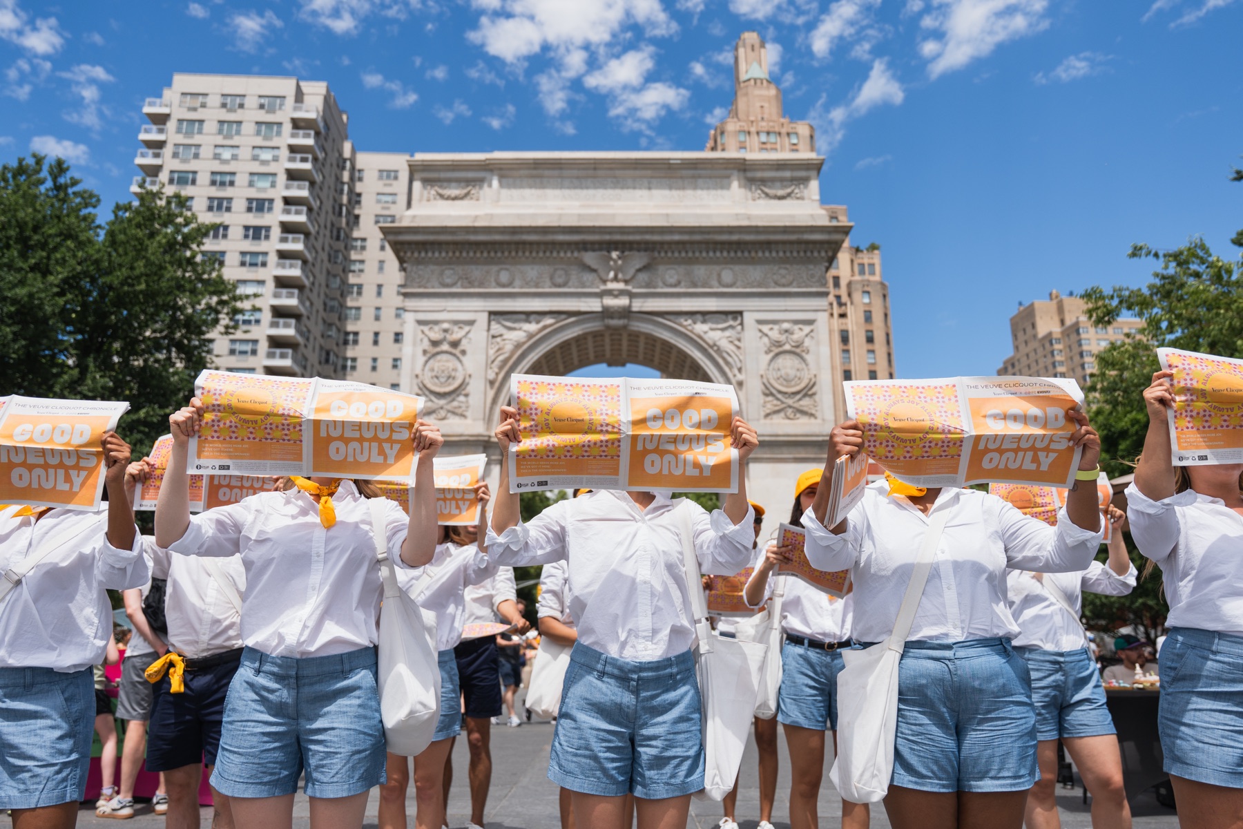 Veuve Clicquot Chasing the Sun — Joy Messengers raise the Good News Only Chronicle beneath the arch at Washington Square Park.